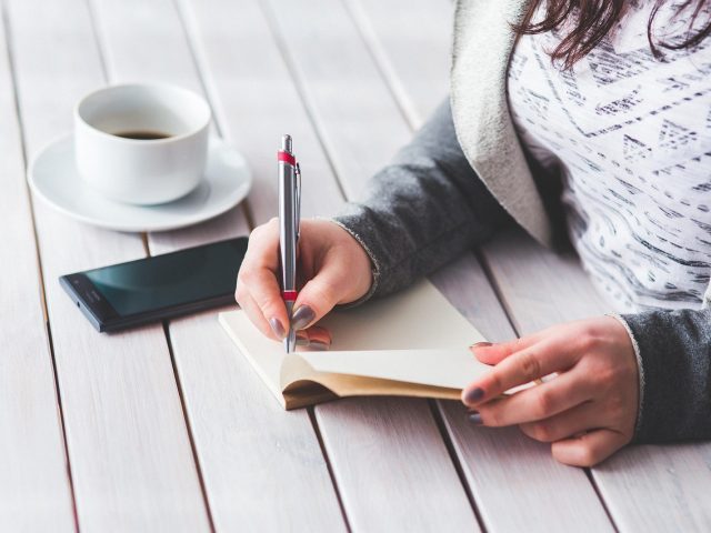 中学生在灯下翻译桃花源记白话译文,课本与笔记本并排,专注备考的日常场景
